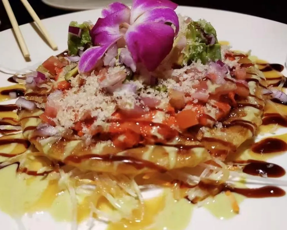 Savory seafood pancake topped with avocado, onion and decorative orchid at Mici Asian Bistro，a Asian Fusion Restaurant in Trumbull